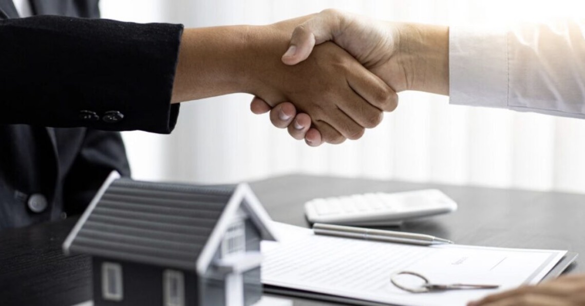 契約書の上で握手する手